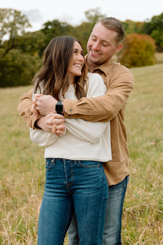 Man hugging woman from behind, smiling at each other