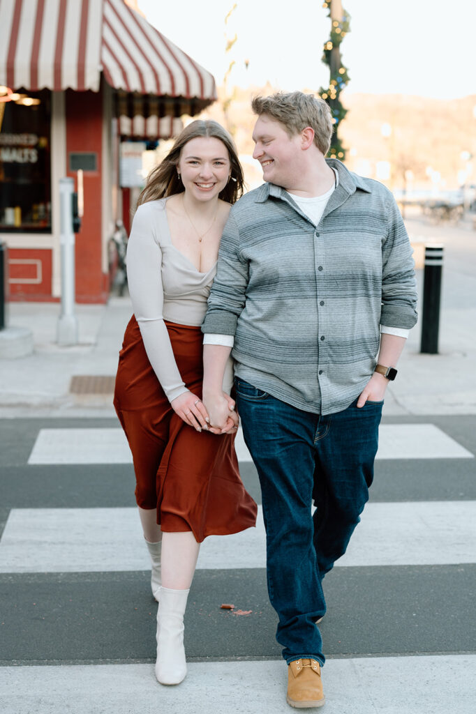 Man and woman walking across a crosswalk holding hands