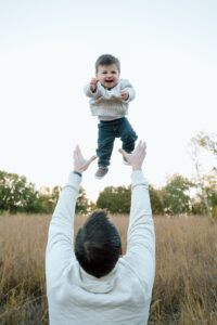 Dad tossing son in the air playfully