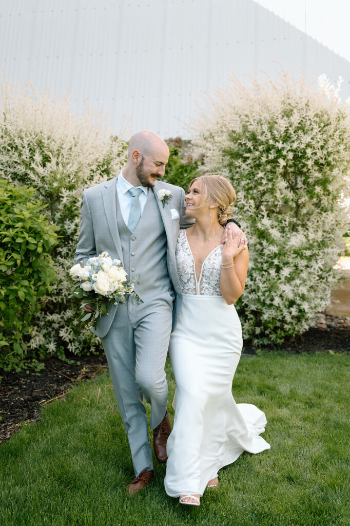 Bride and groom walking with arms around each other